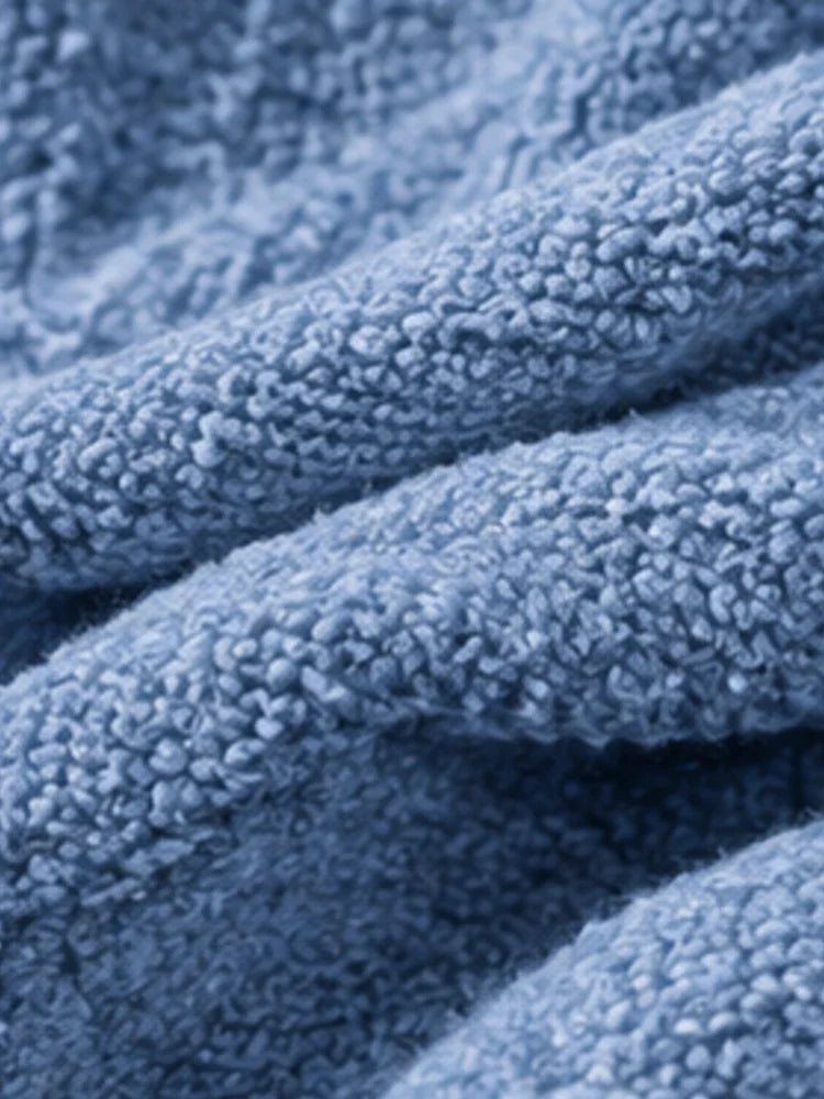 The women's smog-blue solid-color knitted cardigan is made of thick knitted fabric. It has a round neck and front buttons. It is suitable for wearing in autumn and winter, has strong versatility, and has a slightly European-s